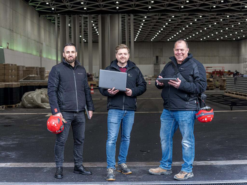 Drei Mitarbeitende der Hälg & Co. AG St. Gallen vor den Toren der SGKB-Halle in St. Gallen