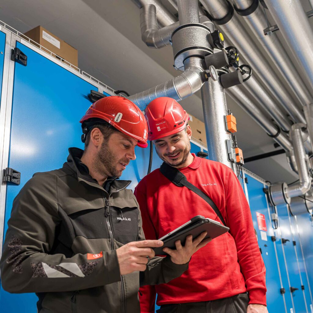 Deux membres du personnel de Hälg Group regardent une tablette affichant le plan numérique du chantier.