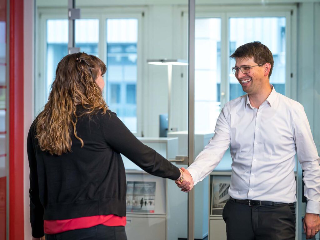 Handshake zwischen einer Kundin der Hälg Group und einem Mitarbeitendem der Hälg Group.