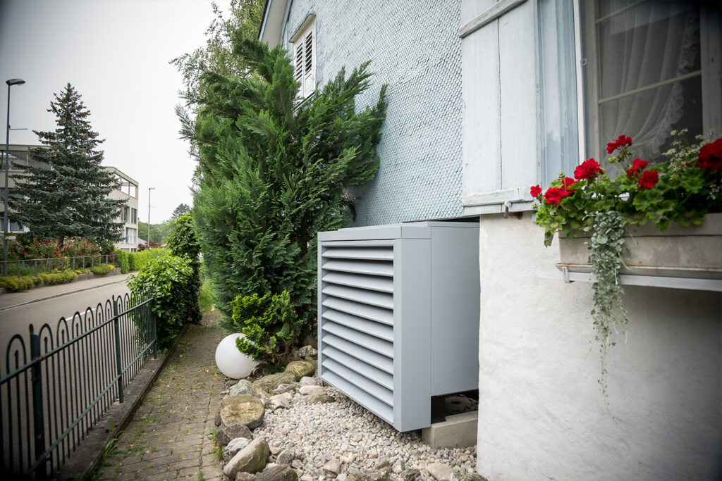 Pompe à chaleur devant une maison individuelle, transformée par le Hälg Group.