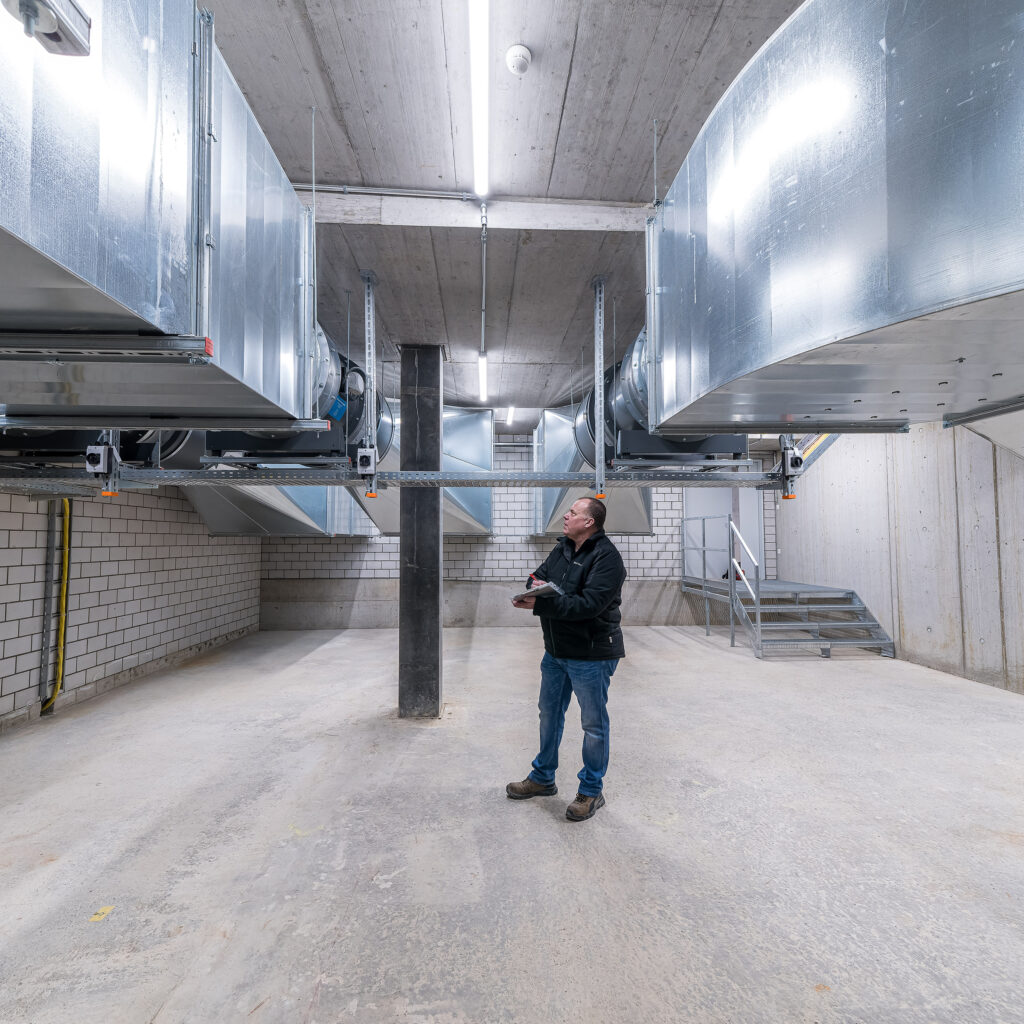 Projektleiter der Hälg & Co. AG St. Gallen vor der Lüftungsanlage der SGKB Halle in St. Gallen.