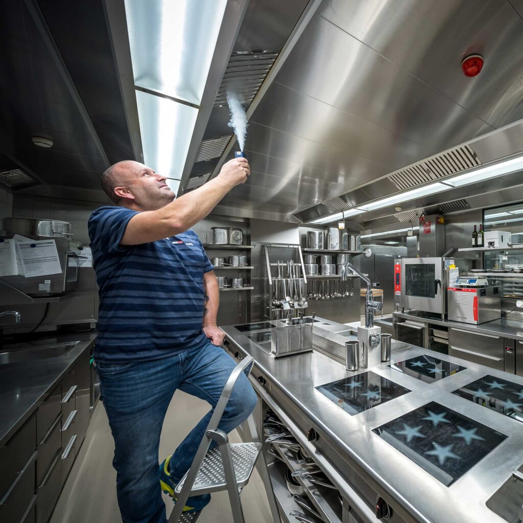 Un nettoyeur d'installations de ventilation de Hälg & Cie SA nettoie les conduits de ventilation d'une cuisine gastronomique.