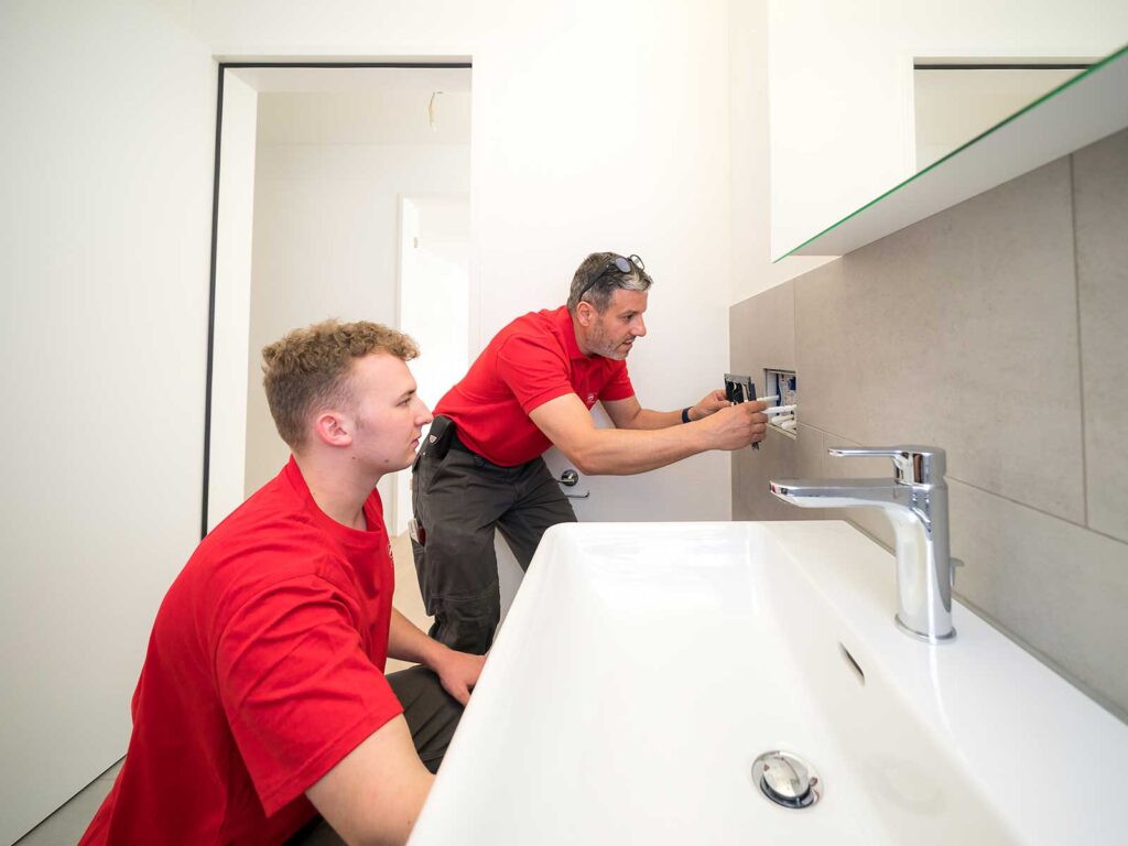 Un collaborateur de Hälg Group instruit 
son installateur sanitaire en formation.