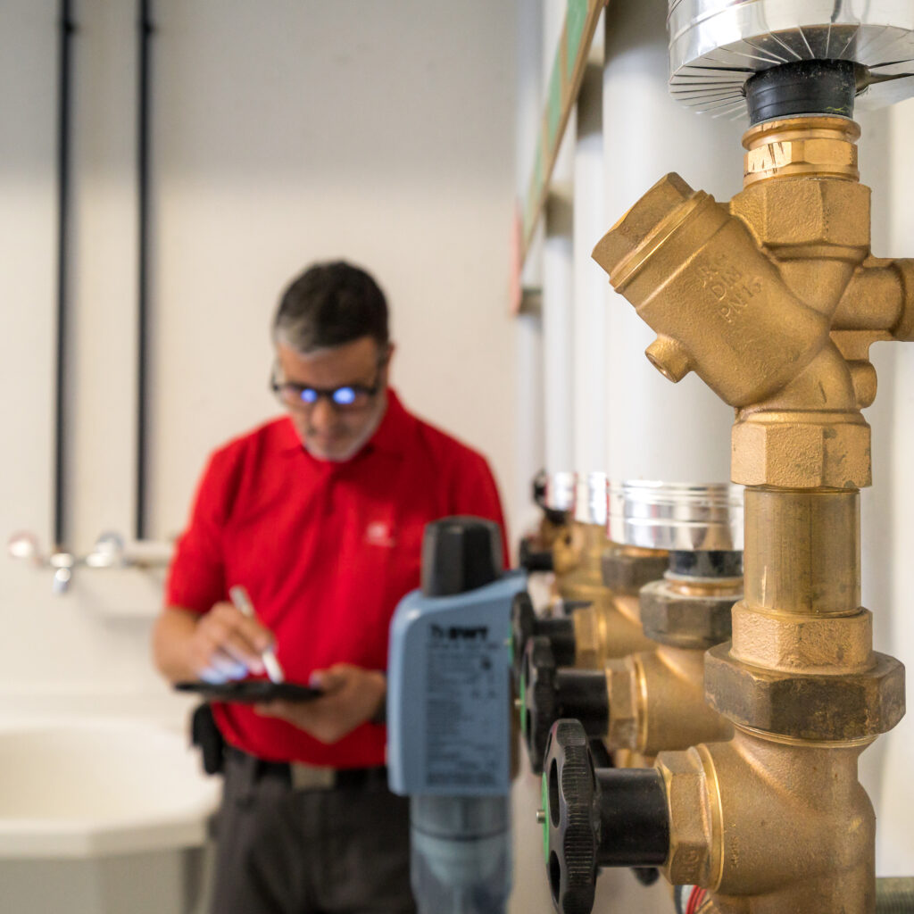 Un technicien en sanitaire de Hälg Group vérifie des installations sanitaires.