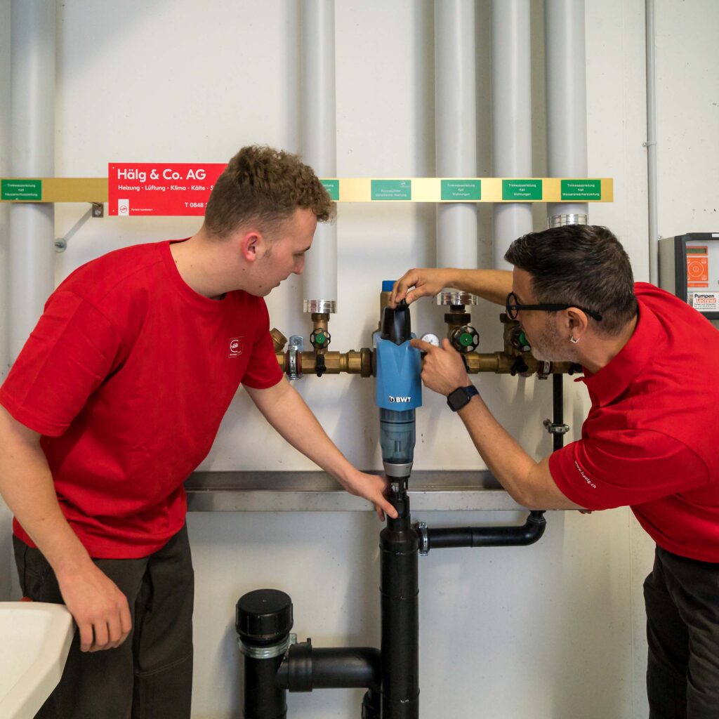 Deux installateurs en sanitaire au travail.