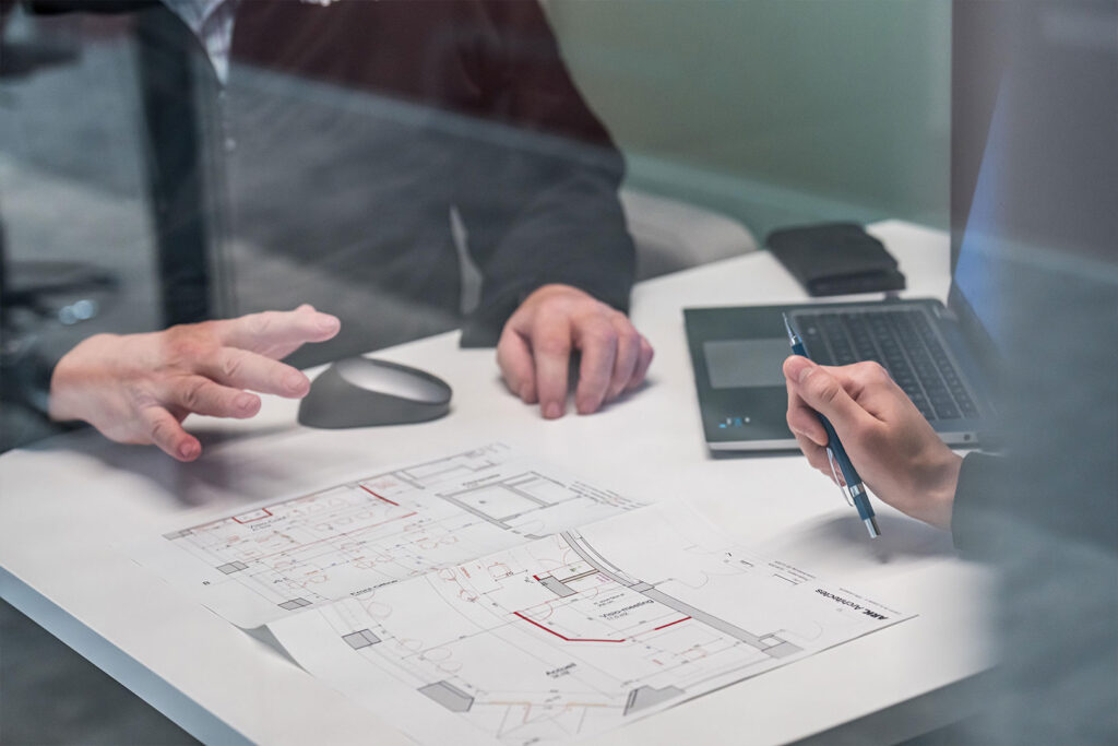 Un plan de bâtiment se trouve sur la table pendant une réunion.