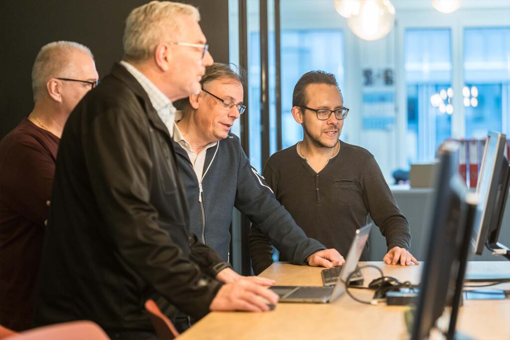 Mitarbeiter der Hälg & Co. AG Zürich im Gespräch am Computer.