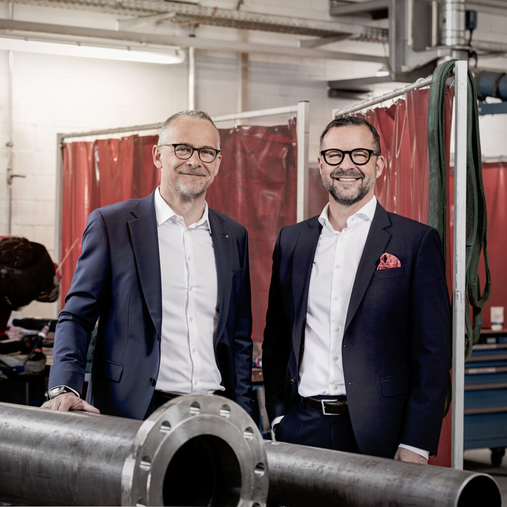 Roger und Marcel Baumer, Inhaber der Hälg Group, stehen gemeinsam in der Werkstatt.