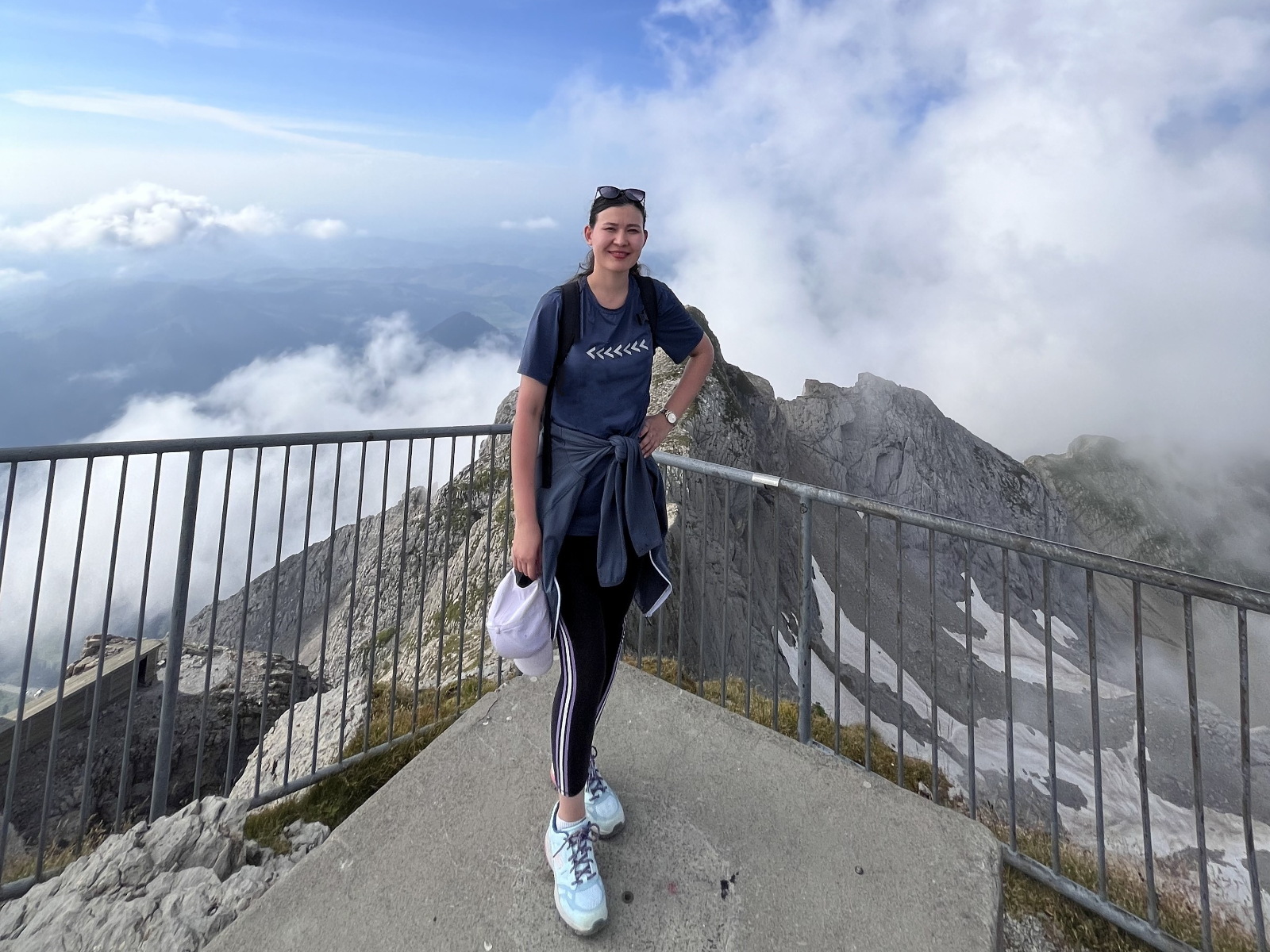 Sie geniesst den Moment am Aussichtspunkt hoch über den Wolken.