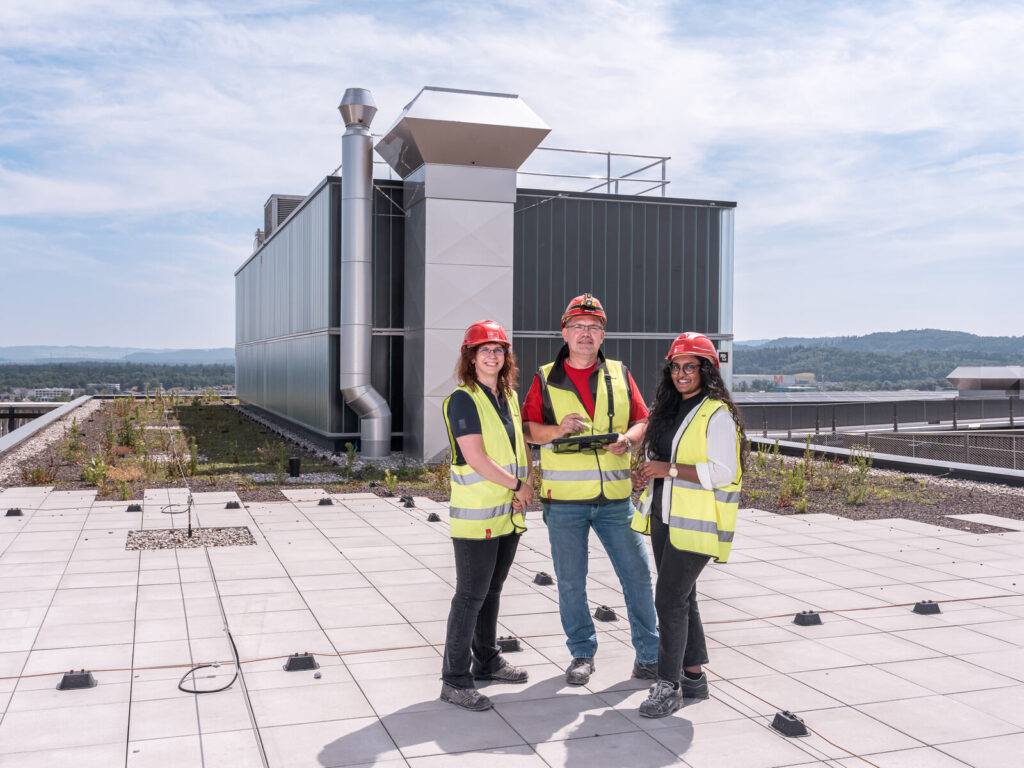 Projektleiterinnen Lüftung und Projektleiter Heizung der Hälg & Co. AG Aarau auf dem Dach des Kantonsspitals Aarau.