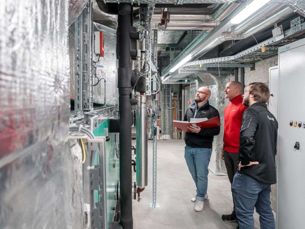 Team der Klima AG in Basel vor Lüftungsanlagen.