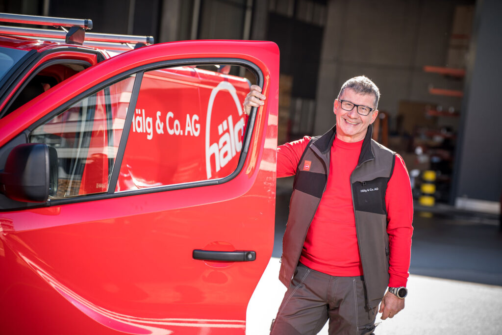 Servicetechniker der Hälg & Co. AG St. Gallen steht neben seinem Auto.