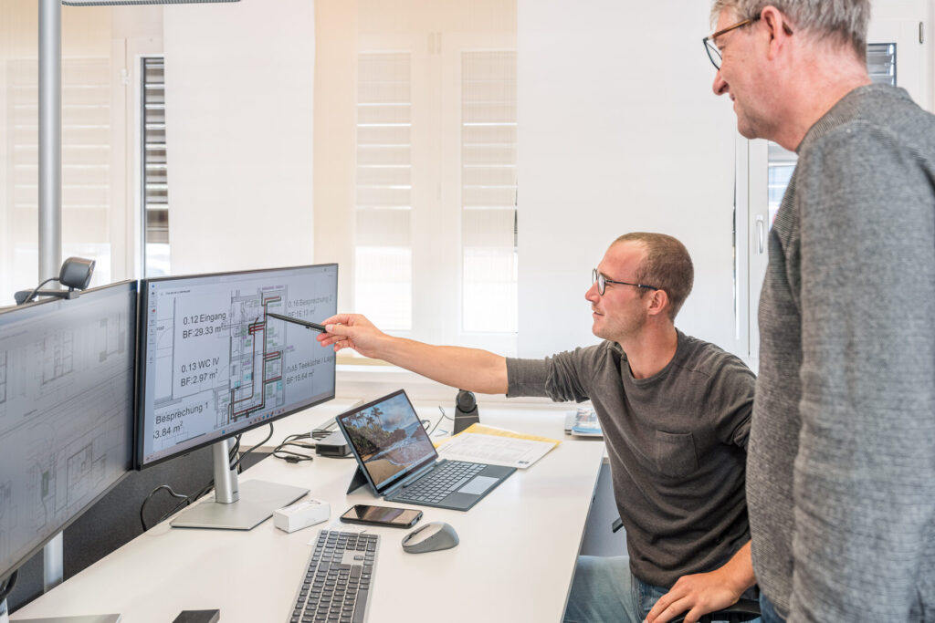 Zwei Projektleiter der Hälg & Co. AG Bütschwil sind vor dem PC in einer Besprechung.