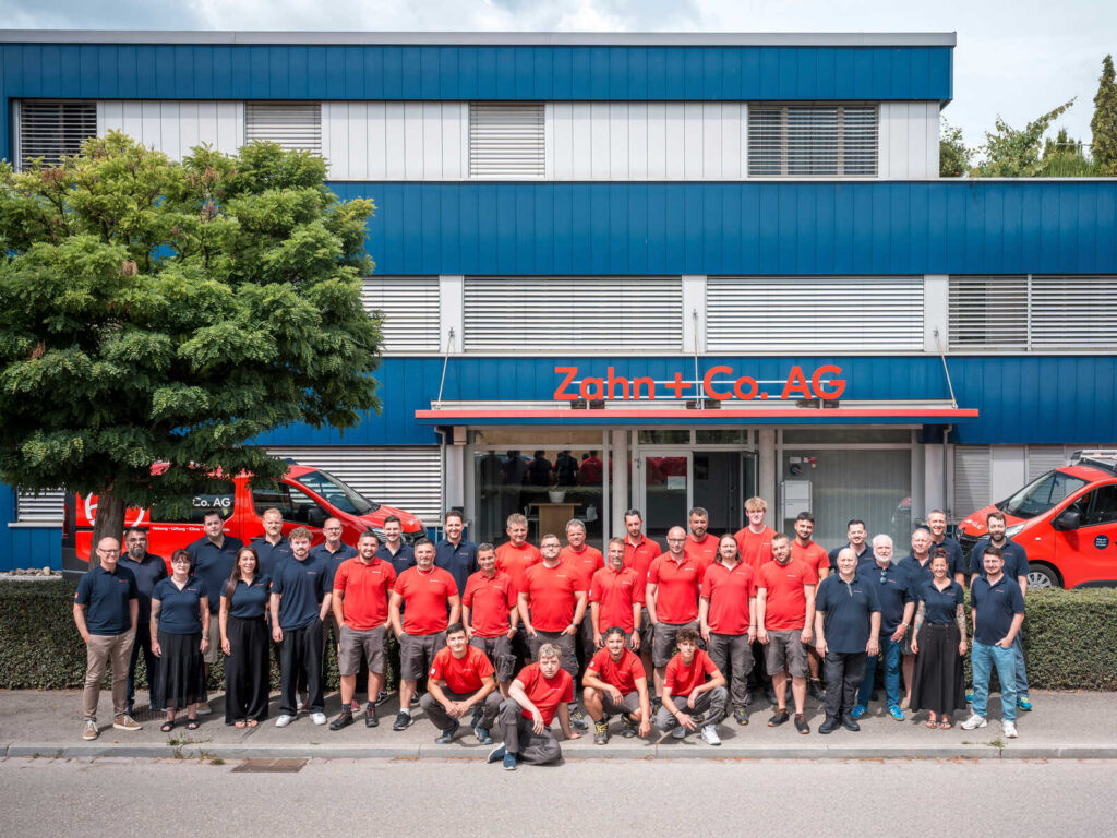Team der Zahn + Co. AG in Kreuzlingen vor ihrem Gebäude.